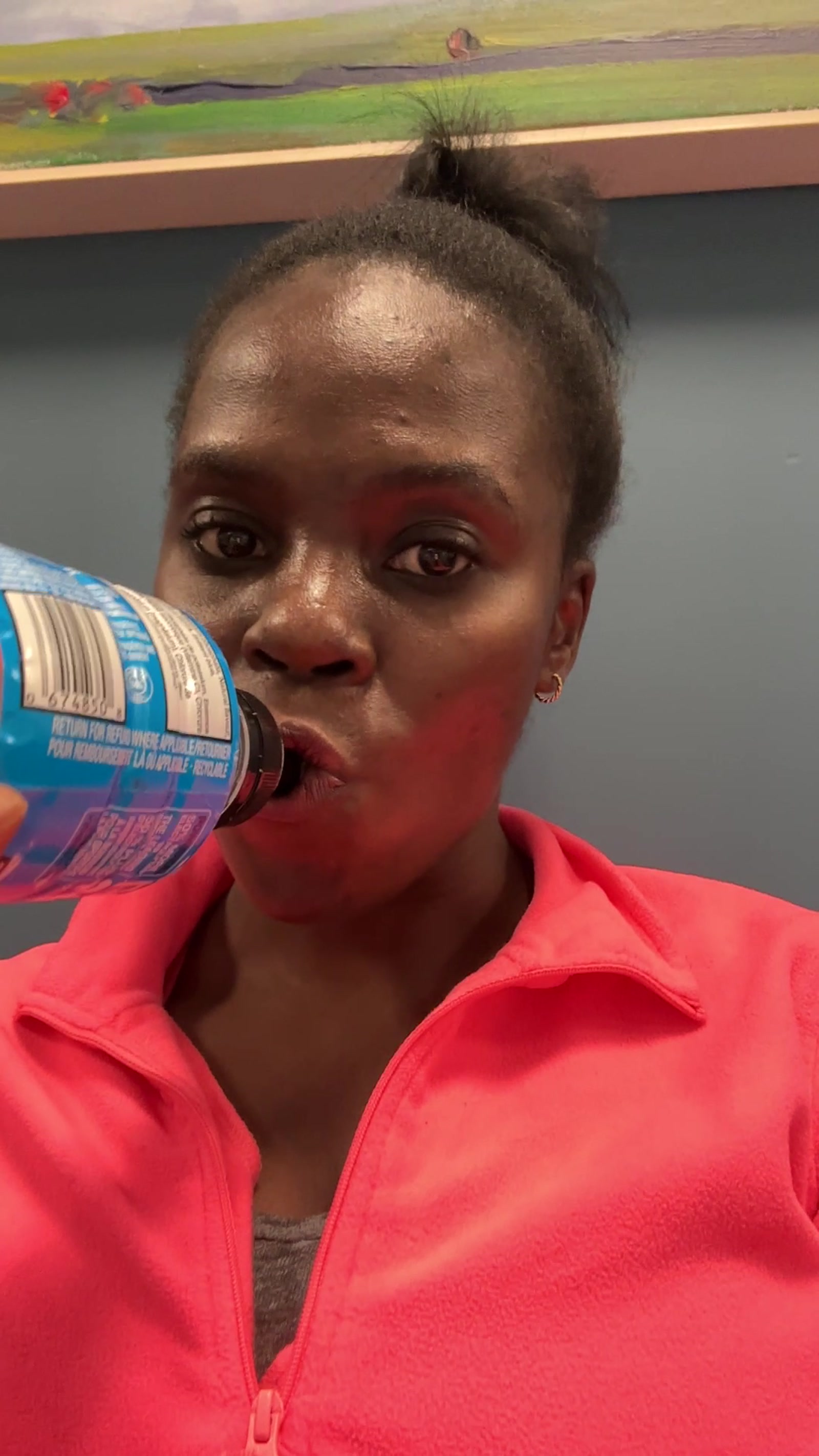 Neola in red sports bra drinking from a sports bottle between stress-test stages