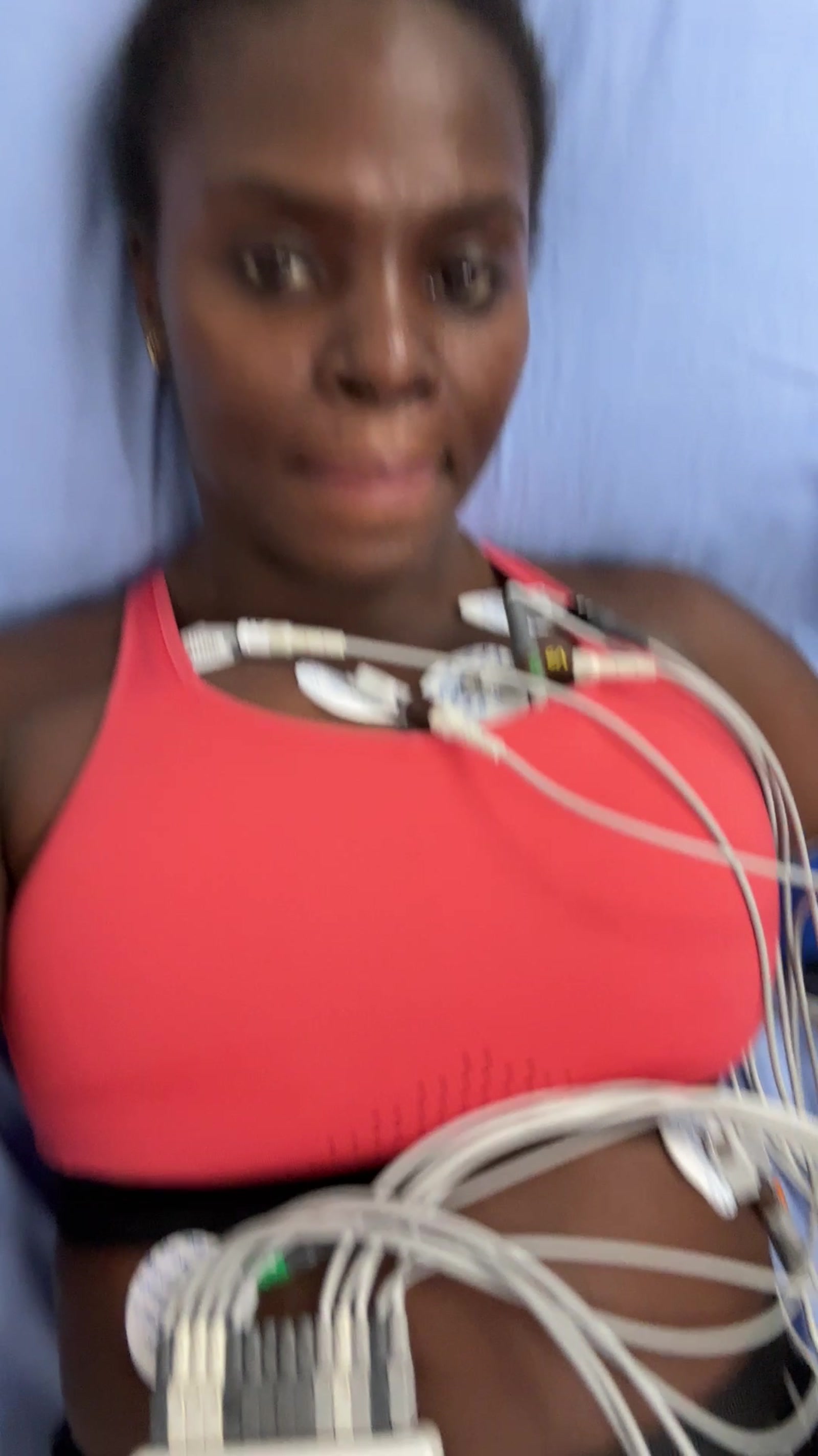 Neola lying on cardiology exam table, ECG leads connected across chest